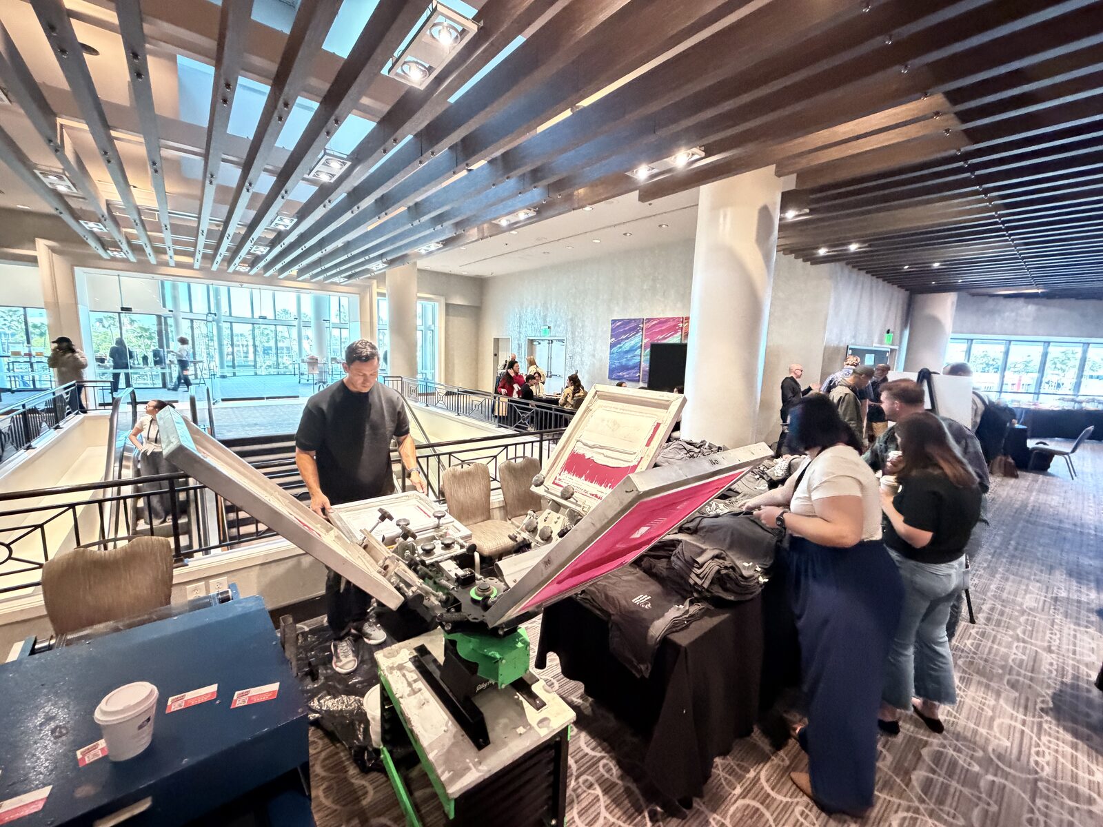 Wide view of a Merch Troop live station on a hotel mezzanine with guests choosing garments